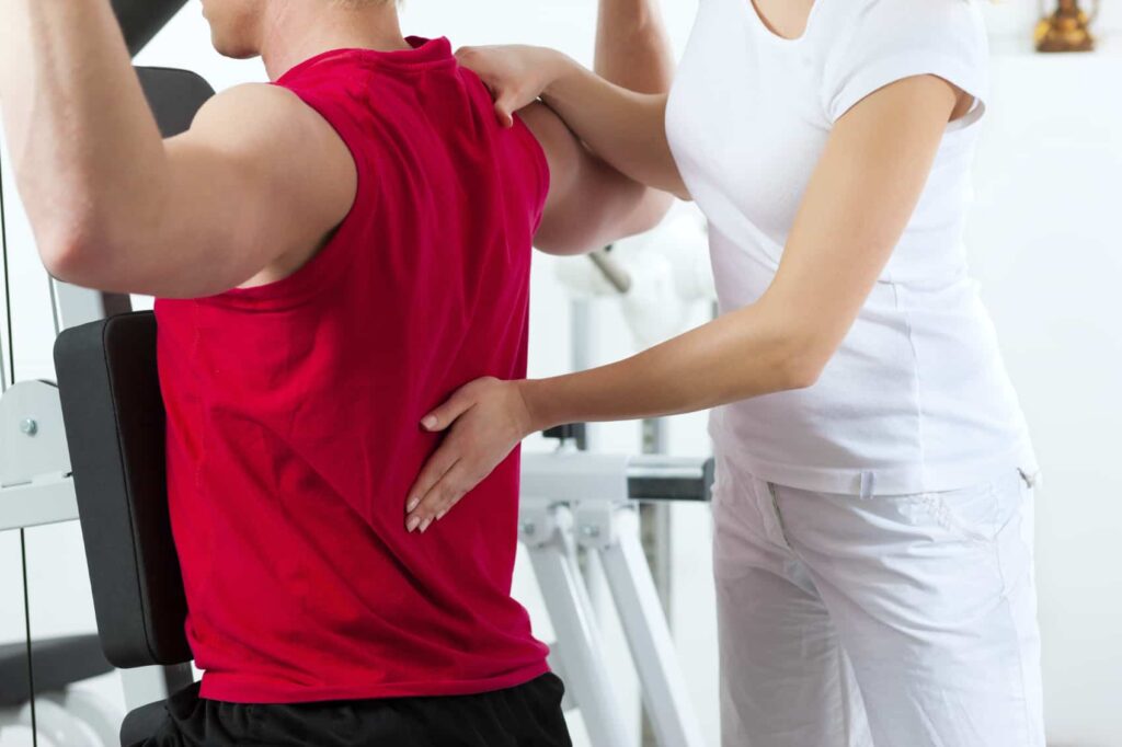 Patient at the physiotherapy making physical exercises with his therapist